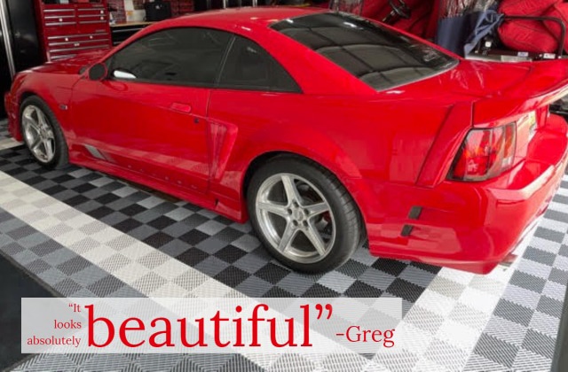 Red car on ribbed garage floor tiles