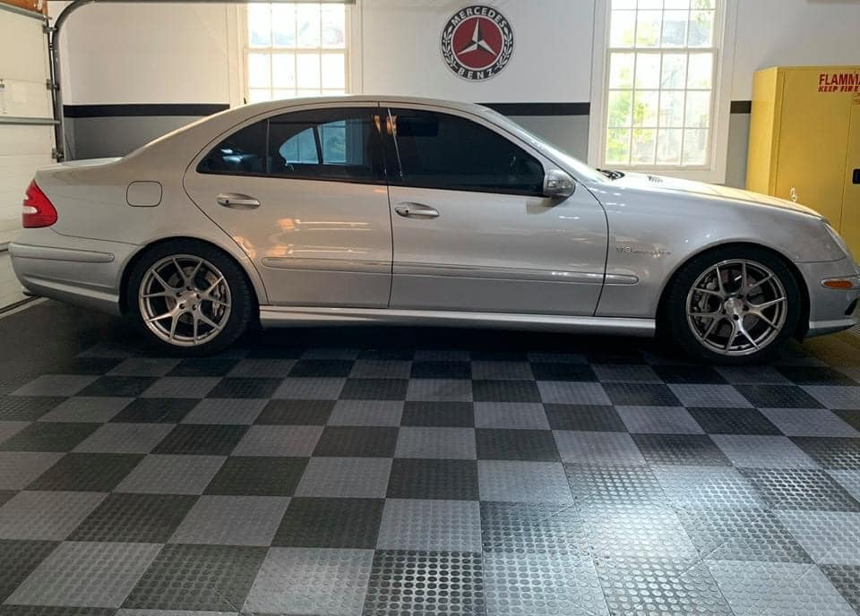 Grey car on top of black and grey checkerboarded tiles